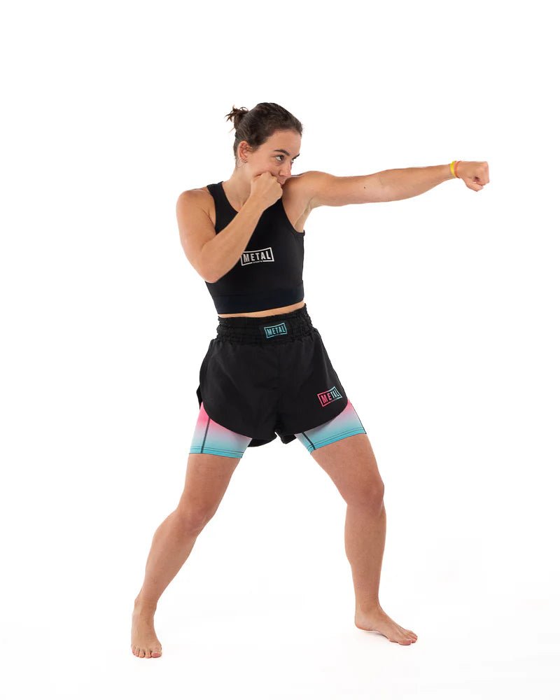 Athlete in action with punch wearing black Metal Boxing compression tank top, tight fit and support