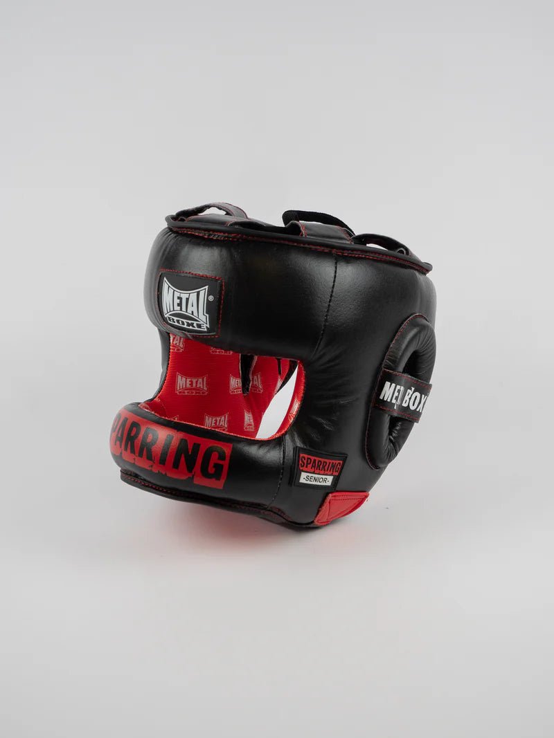 Vedere frontală a căștii neagră Metal Boxing Senior Sparring cu bară de protecție și detalii roșii