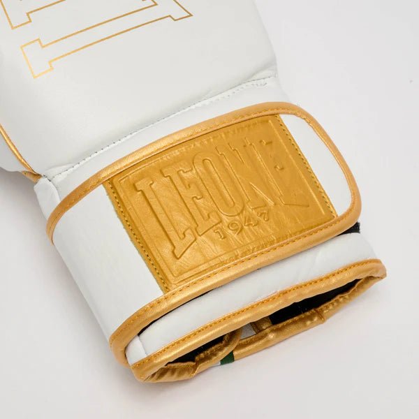 Detalhe do logotipo dourado no fundo de couro branco da luva DNA Premium