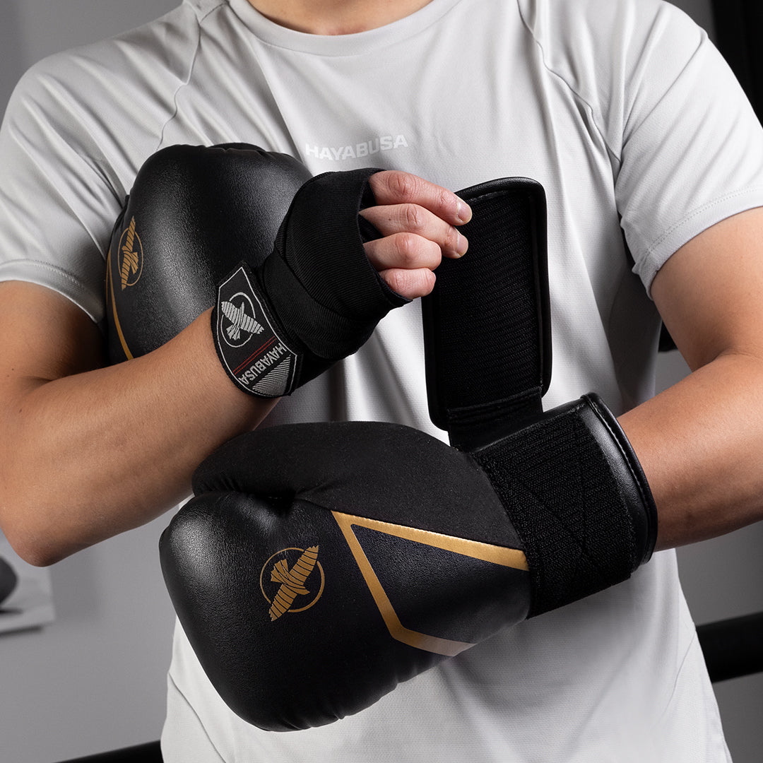 Guantoni da boxe neri e oro Hayabusa E1 indossati durante un allenamento al sacco