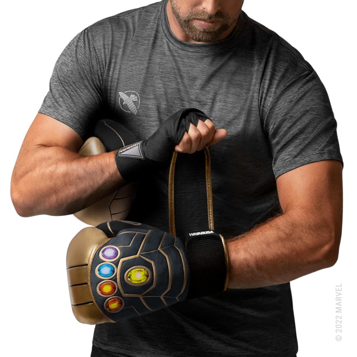 Atleta usando luvas Hayabusa Marvel Thanos douradas e pretas em posição de guarda
