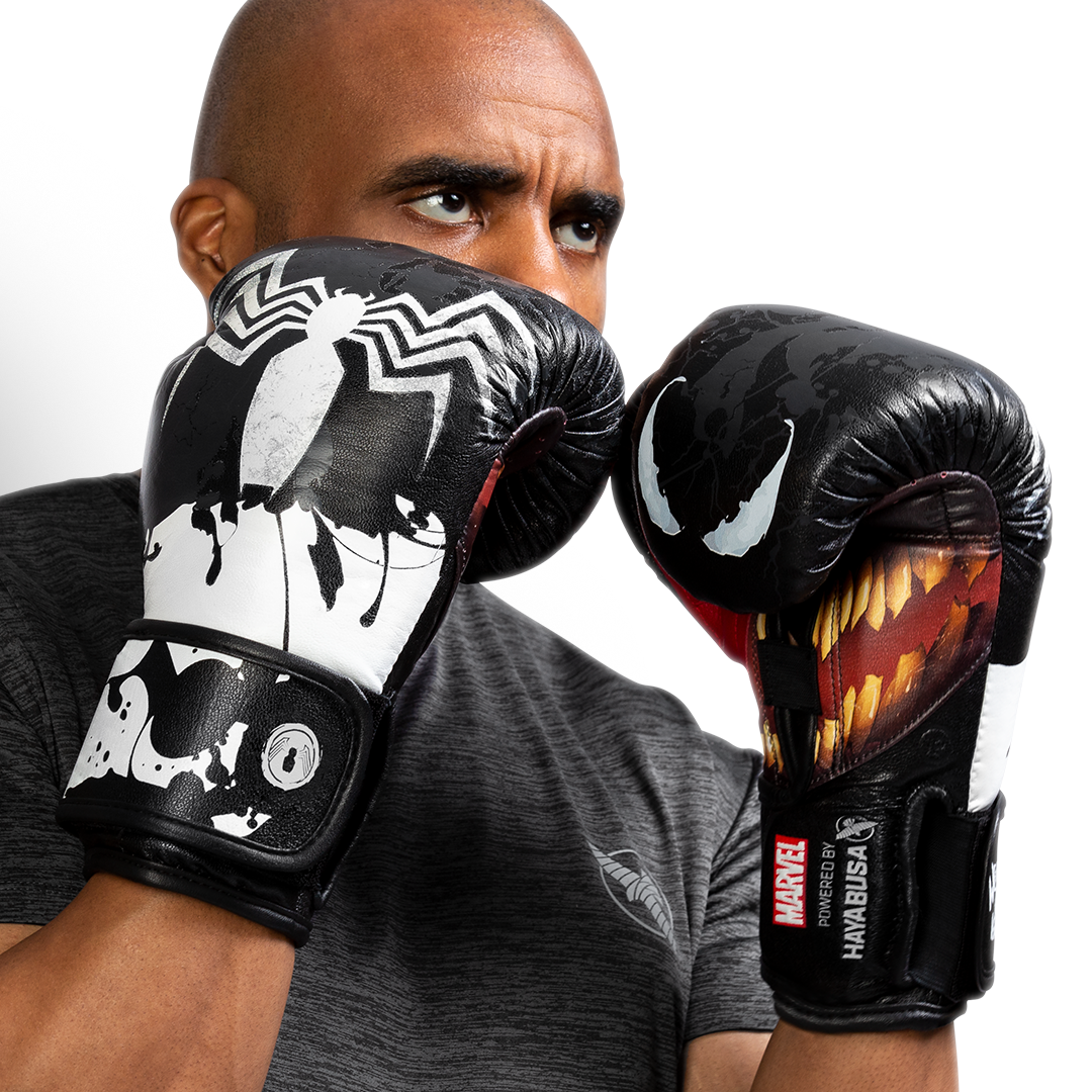 Atleta che indossa i guantoni neri e bianchi Hayabusa Marvel Venom in posizione di attacco