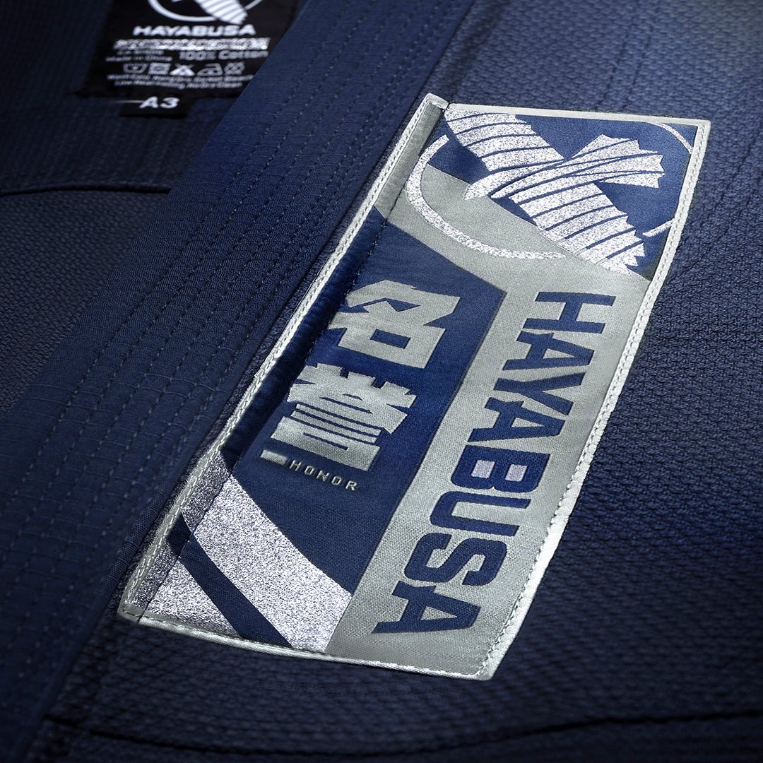 Nahaufnahme des Hayabusa-Schriftzugs und der gestickten Details auf der marineblauen Variante