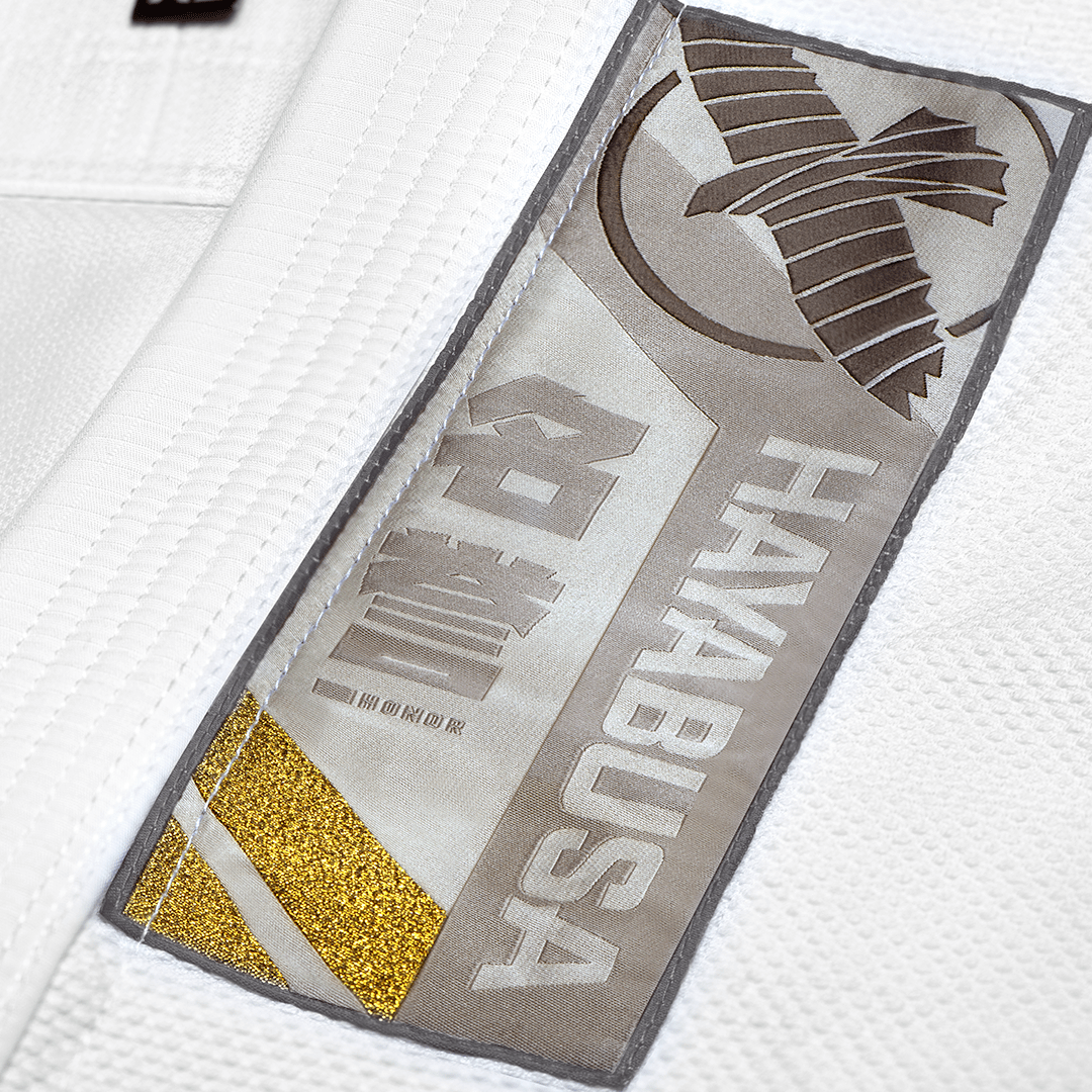 Detail nášivek s kanji a výšivkou na bílém kimonu Hayabusa
