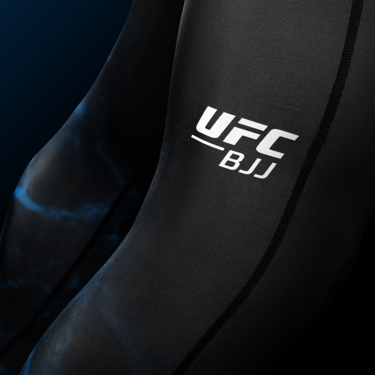 Détail en gros plan de l'écriture UFC imprimée sur la jambe du legging BJJ Spats noir et bleu
