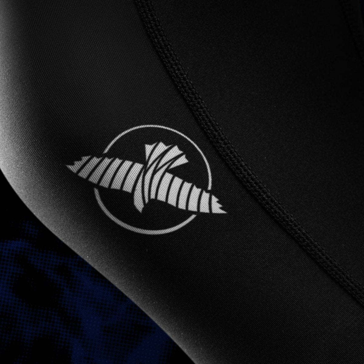 Détail en gros plan de l'écriture UFC imprimée sur la jambe du legging JJB femme noir et bleu