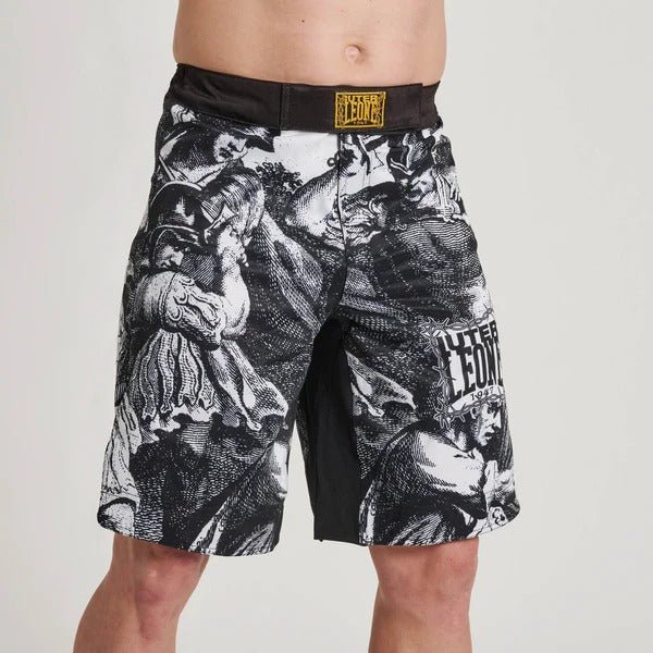 Close-up vooraanzicht van de LEONE x IUTER Prikkeldraad MMA-shorts op één model, met de gedetailleerde klassieke grafische print in graveerstijl en logo's op de broekspijp en de tailleband