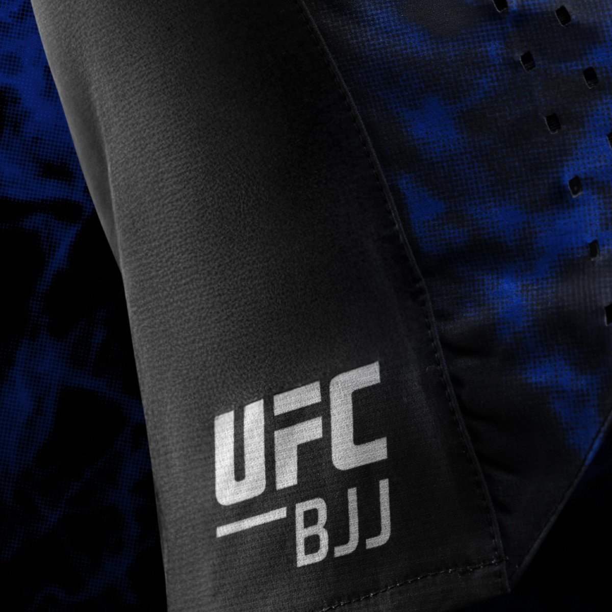 黑色和蓝色女式短裤上印有 UFC BJJ 官方标志的侧面细节