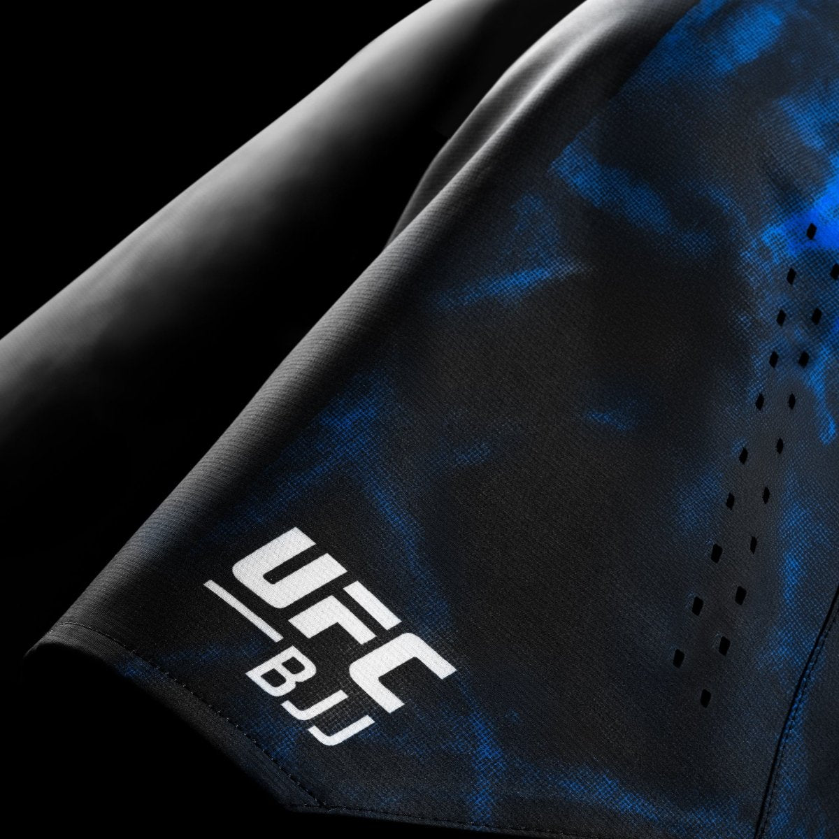 Detail loga a grafiky UFC BJJ na černomodrých soutěžních šortkách