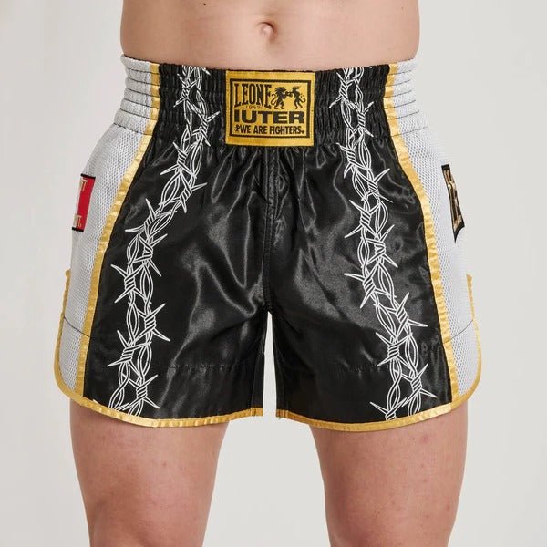 Vista frontal dos shorts LEONE x IUTER Muay Thai com gráficos de arame farpado