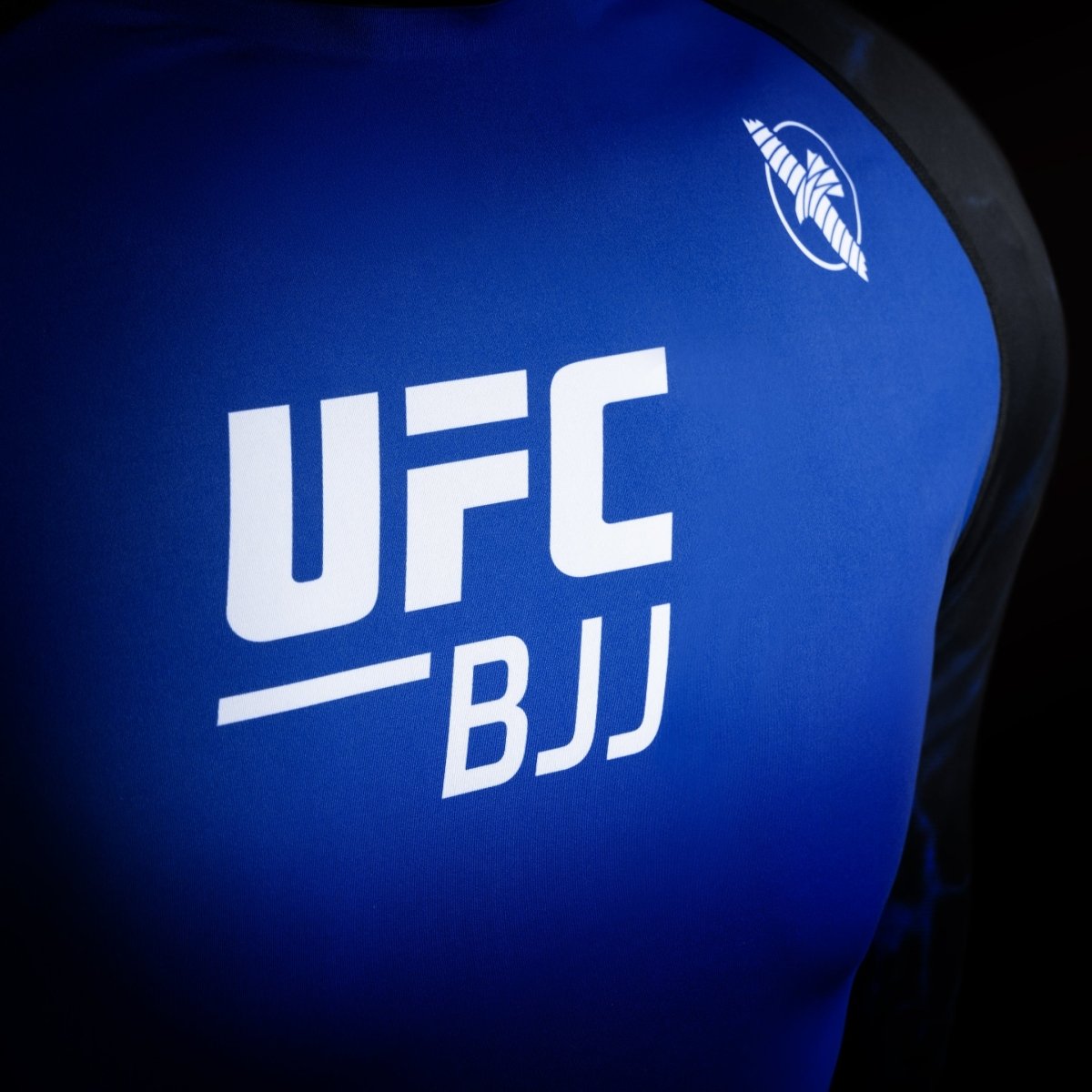 Detail des UFC-Logos auf dem schwarz-blauen Wettkampf-Rashguard, Detail des hochbeständigen Stoffes