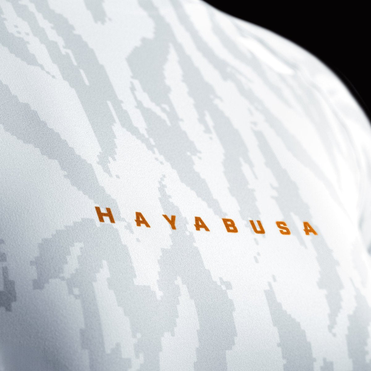 Nahaufnahme des Hayabusa-Frontdrucks auf dem weißen Damen-Rashguard, Detail des geklebten Nahtkragens