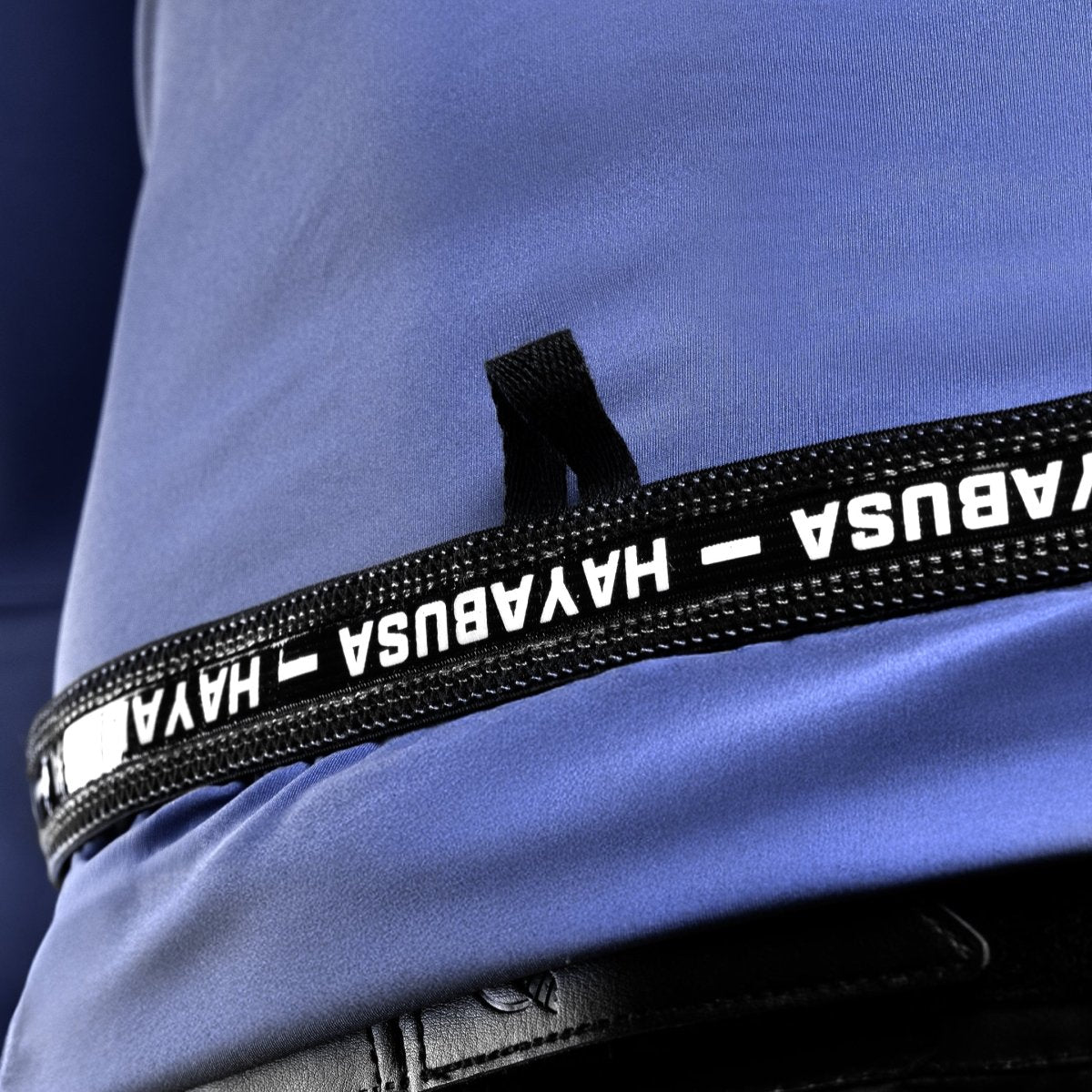 Nahaufnahme des Innendrucks mit Pflegehinweisen und Branding auf dem blauen Rashguard