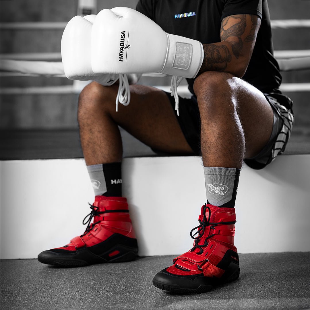 Anziehen der roten Hayabusa Strike-Boxschuhe an einem Boxer, der für den Kampf bereit ist