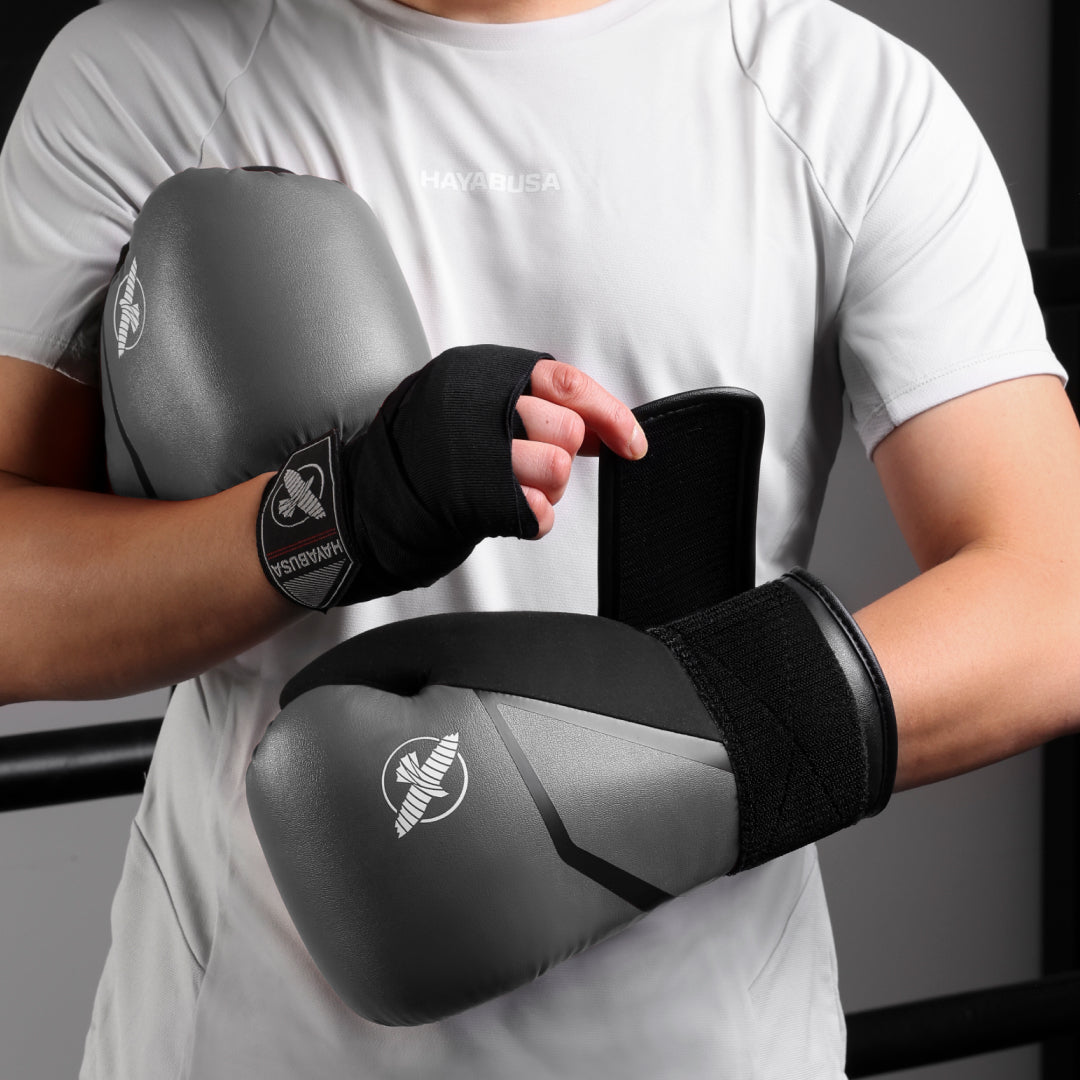 Guantoni da boxe grigi Hayabusa E1 indossati mentre colpiscono i focus mitts
