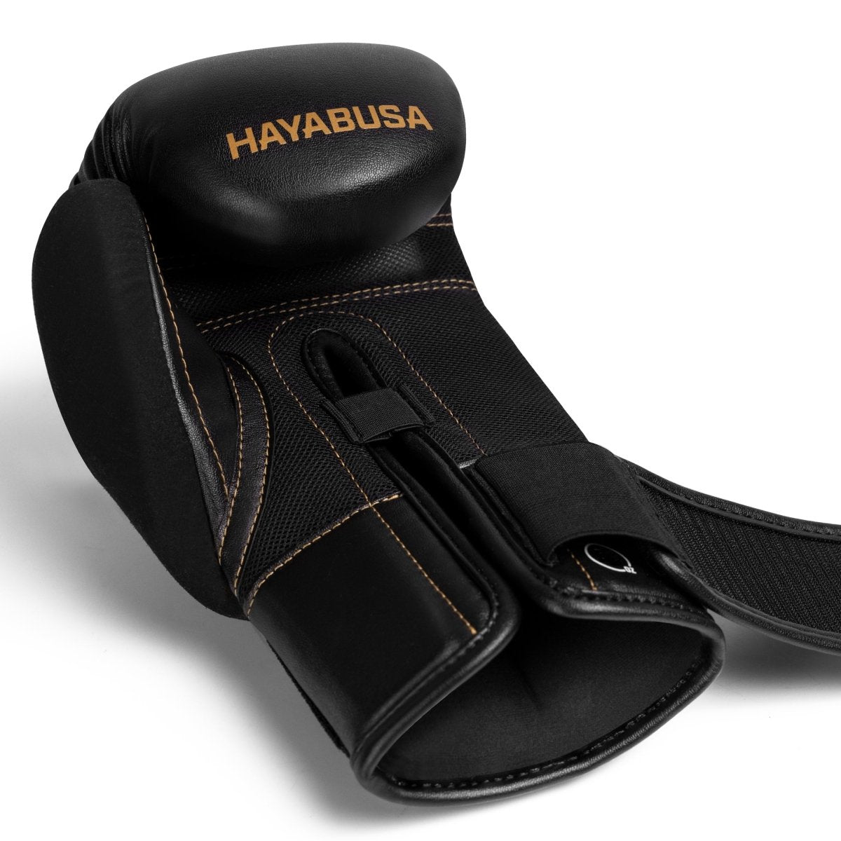 Close-up of the open hook-and-loop closure on the black and gold Hayabusa E1 glove