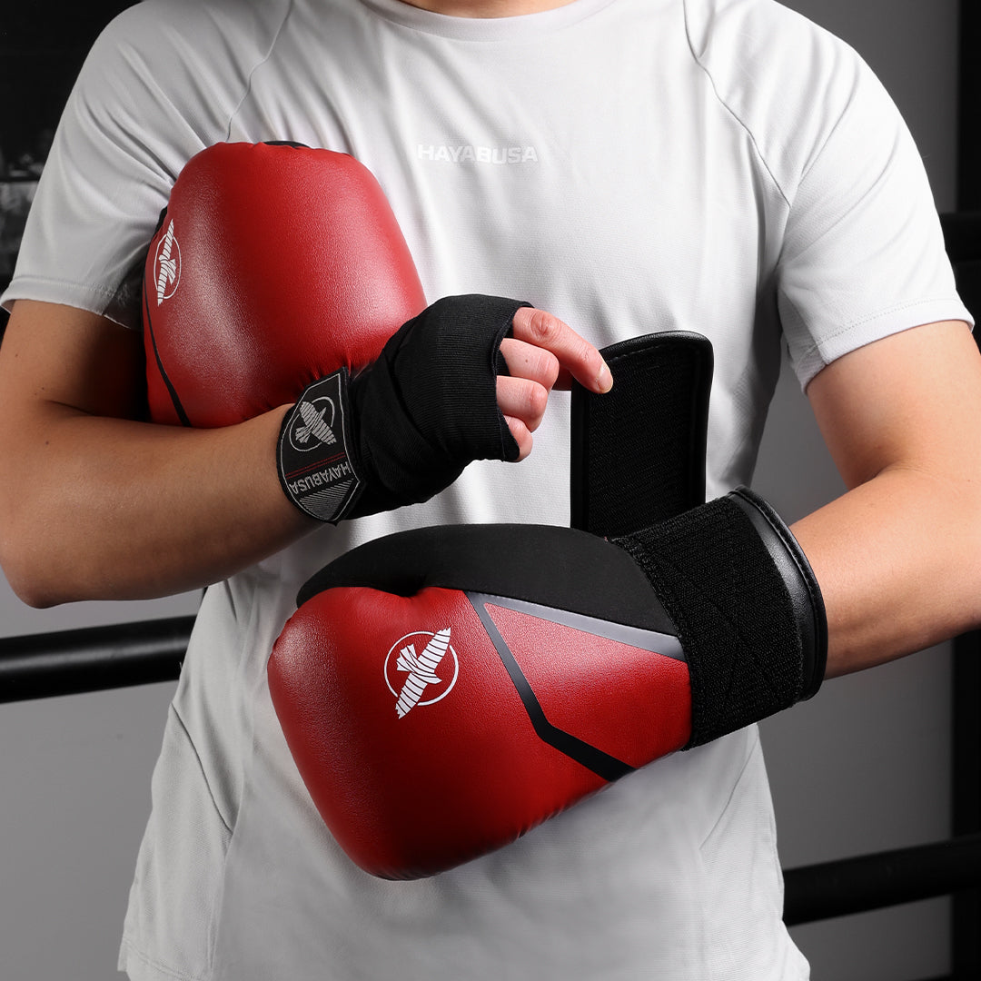 Atleta che indossa i guantoni da boxe rossi Hayabusa E1 in azione di striking