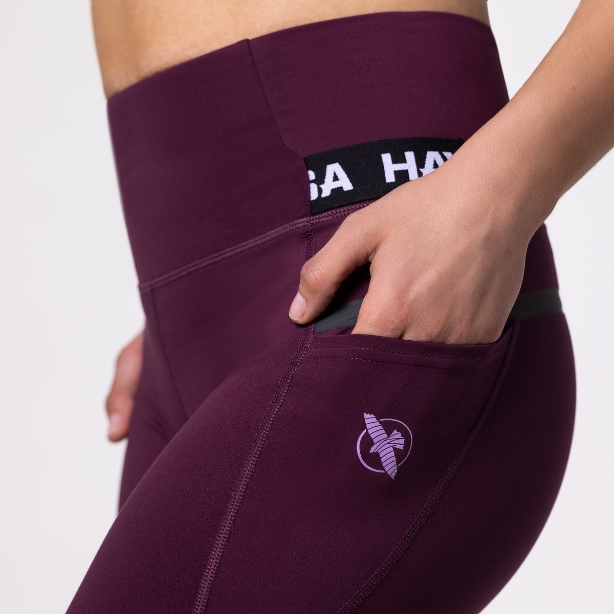 Detalhe do bolso lateral oculto na legging esportiva cor vinho