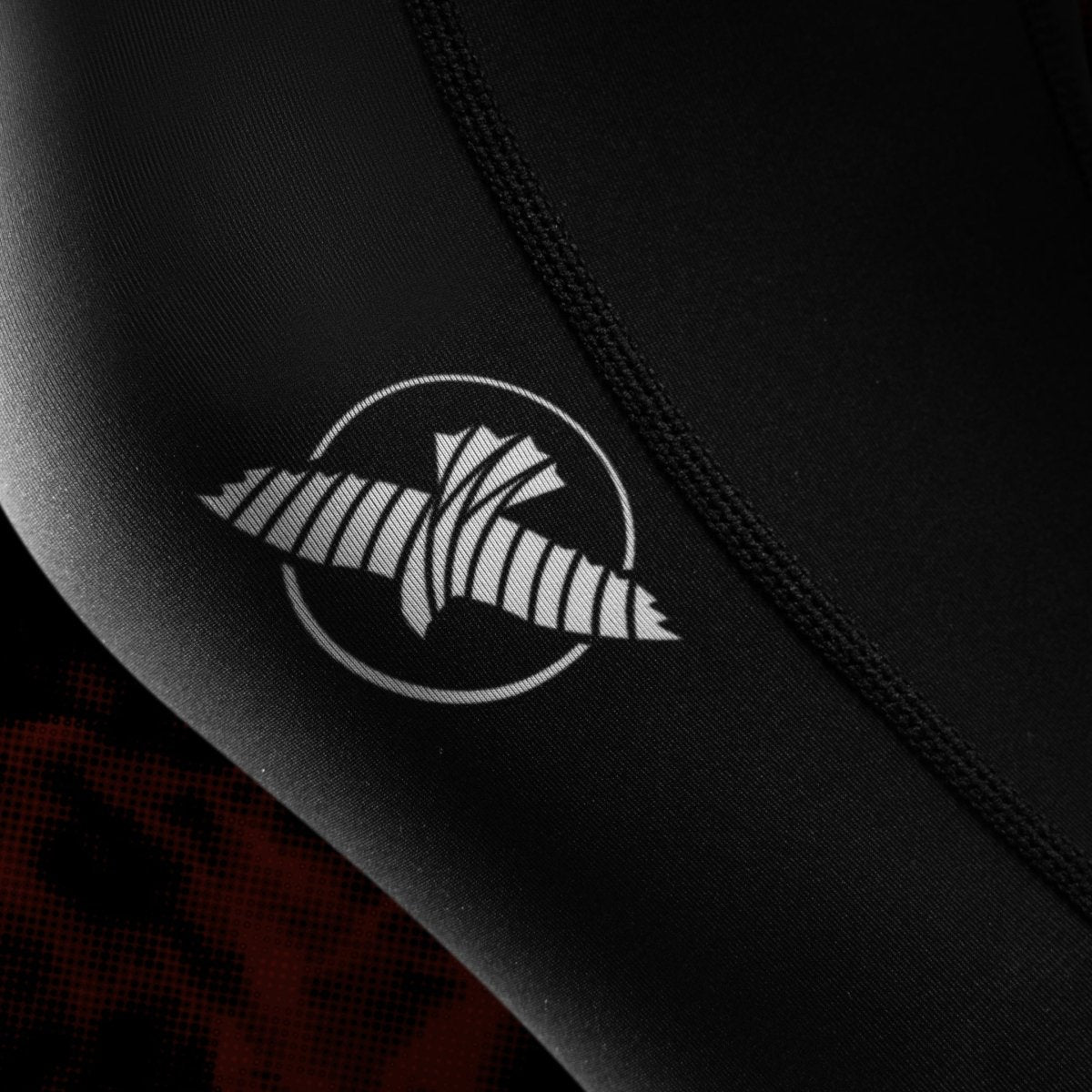 Close do logotipo oficial do UFC e gráficos impressos na perna da legging feminina de Jiu-Jitsu preta e vermelha