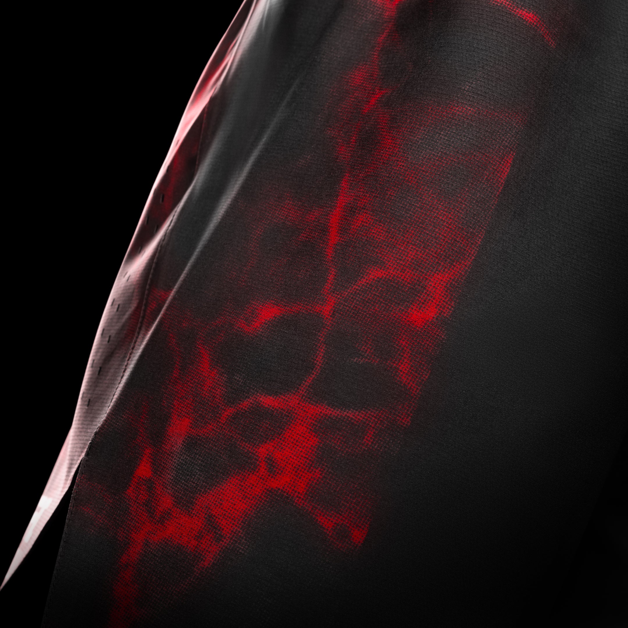 Vista laterale dei pantaloncini UFC BJJ nero e rossi, dettaglio degli spacchi per la mobilità e ventilazione laser