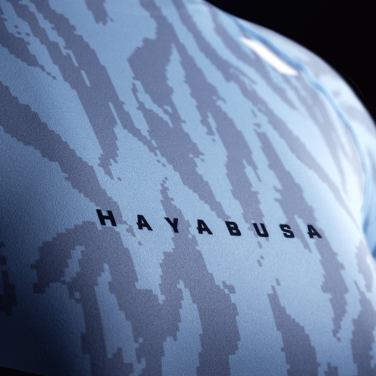 Деталь надписи Hayabusa на груди голубого рашгарда, акцент на переплетении ткани 200 GSM.