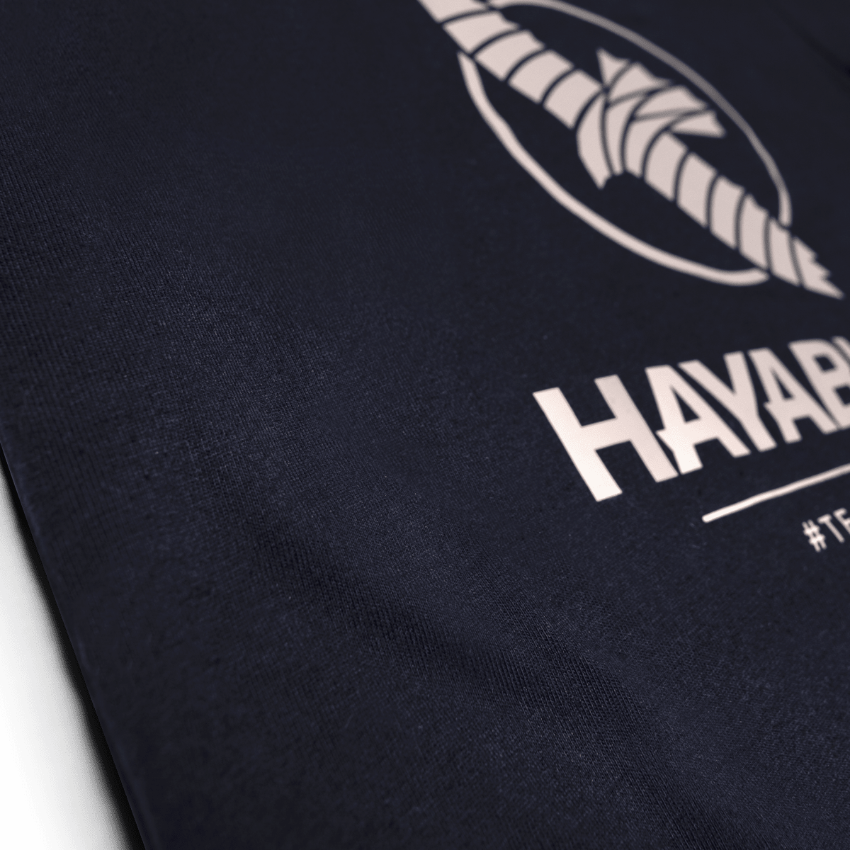 Nahaufnahme der Team Hayabusa-Silikongrafik auf dem nachtblauen T-Shirt